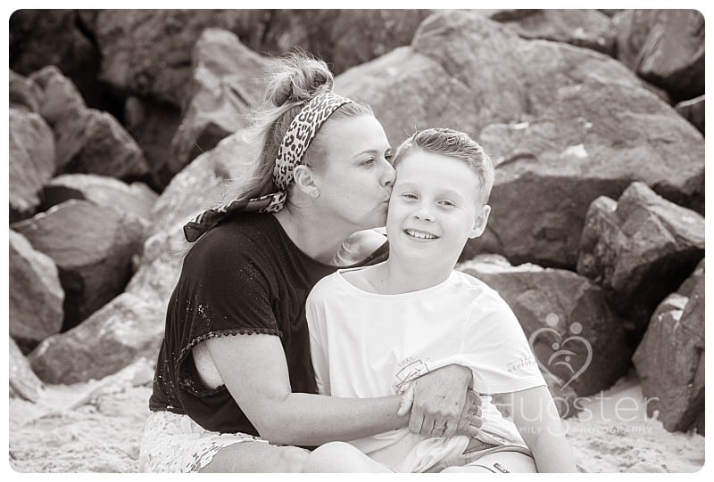 Mum kisses son at the beach black and white Mum kissing son at the beach